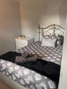 a bedroom with a bed with a black and white comforter at Stylish Darlington Townhouse Near A1 A66 & A19 Breakfast in Darlington