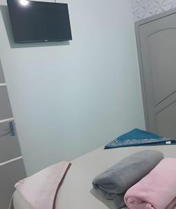 Habitación con cama con almohada y TV. en Pousada Souza Familiar, en Porto Velho