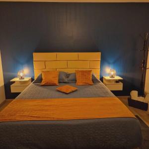 um quarto com uma cama grande e almofadas laranja em les chambres de Sandra em Volognat