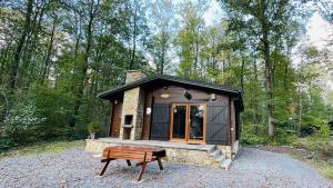 a tiny house in the woods with a bench at Les Trois Feuilles in Petit Mesnil