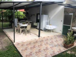 a patio with a table and chairs and a refrigerator at Fresca casa completa Monterrey casanare in Monterrey