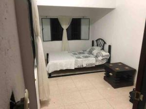 a small bedroom with a bed and a window at Fresca casa completa Monterrey casanare in Monterrey