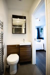 a bathroom with a toilet and a sink and a bed at Dunstable Rd Modern Ensuites by Pioneer Living in Luton