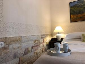 a bedroom with two beds and a table with two cups at Porfyra Deluxe Guesthouse in Kalavrita