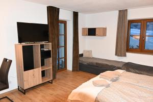 1 dormitorio con 1 cama y TV de pantalla plana en Nicky, en Niederau