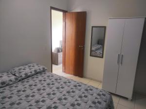 a bedroom with a bed and a closet and a mirror at Apartamento inteiro próximo a Algar, Cargill, Aeroporto e UFU in Uberlândia