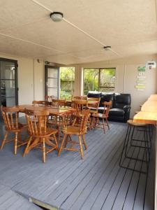 een woonkamer met een houten tafel en stoelen bij Tasman Motor Camp in Tasman