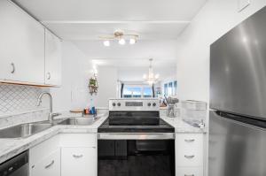 a kitchen with white cabinets and a stainless steel appliance at Oceanfront Jewel - Remodeled to Perfection in Rehoboth Beach
