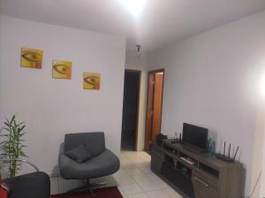 ein Wohnzimmer mit einem Stuhl und einem TV in der Unterkunft Apartamento inteiro próximo a Algar, Cargill, Aeroporto e UFU in Uberlândia