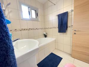 ein Badezimmer mit einer weißen Badewanne, einem Waschbecken und einer Dusche in der Unterkunft Aurora Holiday Apartment - Ayia Napa in Ayia Napa