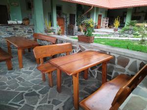 un grupo de mesas y sillas de madera en un patio en Pivnica a Penzion pri studni en Detva