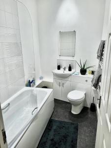 a white bathroom with a toilet and a sink at Home In The Heart Of Southsea in Portsmouth