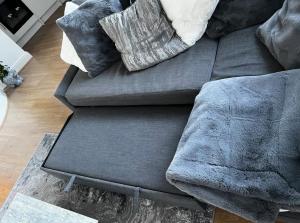 a gray couch with pillows on it in a living room at Home In The Heart Of Southsea in Portsmouth