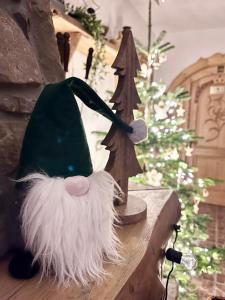 a santa hat sitting on a table next to a christmas tree at Willa Kosówka - Apartamenty i pokoje in Zakopane