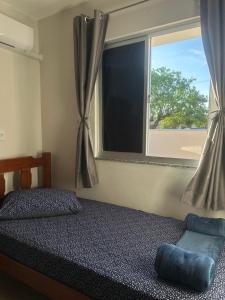 パリョサにあるPousada paraíso Ap próximo ao centro da praia de baixoのベッドと窓のある寝室
