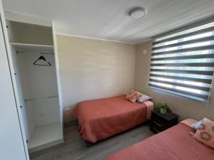 a bedroom with two beds and a window at Departamento nuevo con perfecta ubicación in Osorno