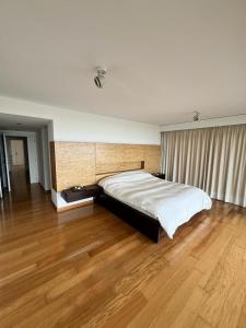 埃斯特角城的住宿－Penthouse Villa brava，卧室内的一张大床,铺有木地板