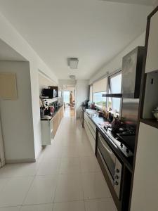 una grande cucina bianca con un lungo piano di lavoro di Penthouse Villa brava a Punta del Este