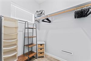 a closet with a shelf and a clothes rack at Stay and Play in Luxury Coffey Villas in Garden City