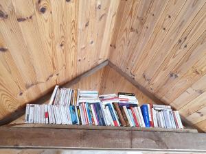 una pila de libros en una pared de madera en Le Parc Lann, en Sainte-Brigitte