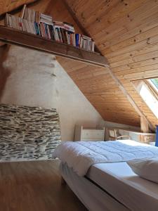 a bedroom with a bed and a shelf with books at Le Parc Lann in Sainte-Brigitte
