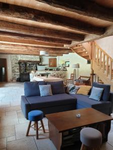 a living room with a blue couch and a table at Charmante longère forestière proche Lac de Guerlédan in Sainte-Brigitte
