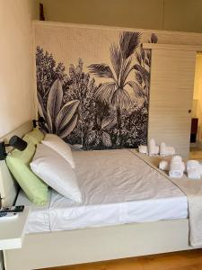 a bed with white pillows and a wall with plants at La Matilde in Viareggio