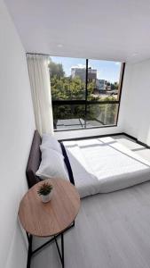 1 dormitorio con cama, mesa y ventana en Movistar arena 302, en Bogotá