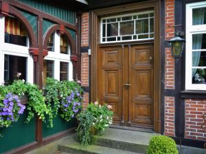 a wooden door on a brick building with flowers at Theeshof in Soltau