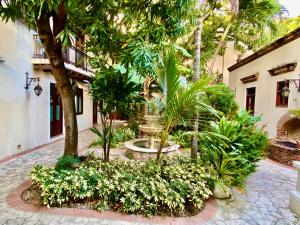 a courtyard with a fountain and trees and plants at Ermitage in Santo Domingo