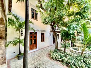 un patio con palmeras y un edificio en Ermitage en Santo Domingo