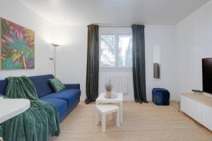 uma sala de estar com um sofá azul e uma televisão em Le St-Charles#Wifi#TGV em Marselha
