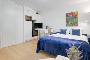 um quarto branco com uma cama azul e uma cozinha em Le St-Charles#Wifi#TGV em Marselha