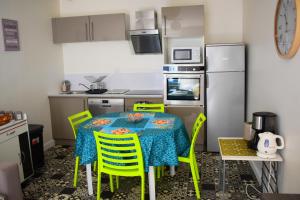 a kitchen with a table with chairs and a refrigerator at Logement cozy proche du centre-ville in Poitiers