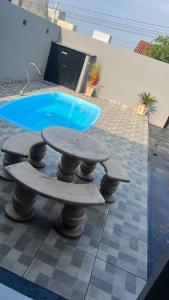 una mesa y un banco junto a una piscina en Área de lazer espaço Reis, en São José do Rio Preto