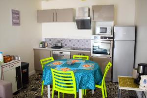 uma cozinha com uma mesa com cadeiras amarelas e um frigorífico em Logement cozy proche du centre-ville em Poitiers