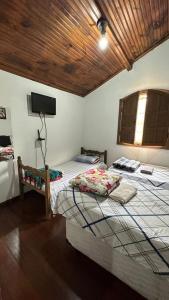 a bedroom with two beds and a flat screen tv at Hostel do Mirante in Ouro Preto