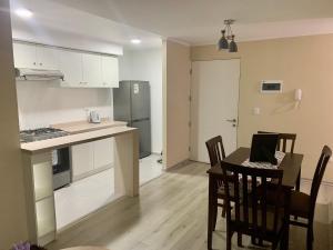 eine Küche und ein Esszimmer mit einem Tisch und Stühlen in der Unterkunft Departamento nuevo con perfecta ubicación in Osorno