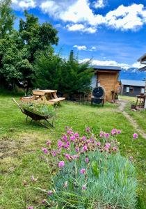 a picnic table and flowers in a yard at Siempre Verde in Puerto Tranquilo