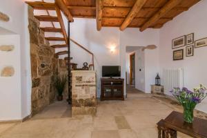 a living room with a stone wall and a television at Gavalochori Stone House in Gavalochori
