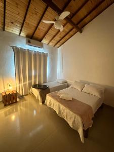 um quarto com 2 camas e uma ventoinha de tecto em Pousada Safira - Coração da Serra do Cipo em Santana do Riacho