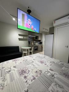 een slaapkamer met een bed en een flatscreen-tv bij STUDIO PROXIMO A PAULISTA in Sao Paulo