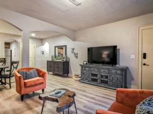 a living room with a flat screen tv and orange chairs at Large Plaza 2BR BTH in Kansas City