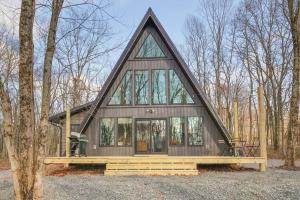 a small house with a triangular roof in the woods at Modern A-frame in woods with Sauna, HotTub, Privacy in Albrightsville