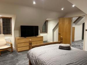 a bedroom with a bed and a flat screen tv at Broadway Pool House with Sauna & Jacuzzi in Herne Bay