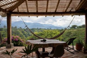 a patio with a hammock and a table and chairs at Finca La Colina in Armenia