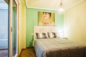 1 dormitorio con 1 cama con una pintura en la pared en Casa Losada, en Monforte de Lemos