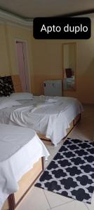 two beds in a room with aqro dipico on top of it at Hospedaria Monumento in Sao Paulo