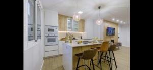 a kitchen with white cabinets and a counter with bar stools at Picasso 2 Luxury in Málaga