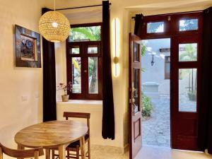 a dining room with a wooden table and a door at Ermitage in Santo Domingo